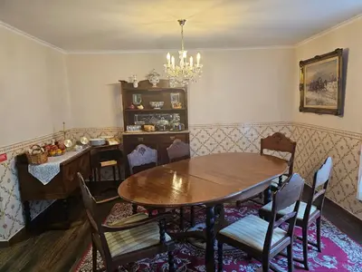 a dining room with a wooden table and chairs at Casa Das Videiras in Seixal