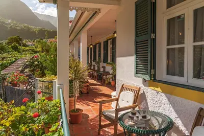 a balcony of a house with a table and chairs at Casa dos Terços by An Island Apart in São Vicente