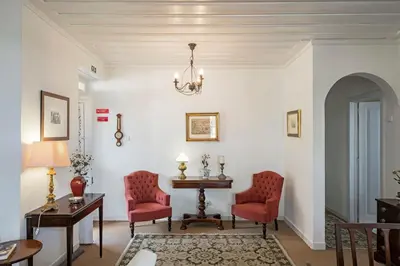 a living room with two red chairs and a table at Casa dos Terços by An Island Apart in São Vicente