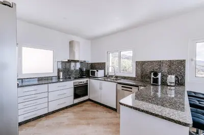 a kitchen with white cabinets and a counter top at Casa das Voltinhas in Ponta do Sol