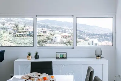 a white desk with three windows in a room at Casa das Voltinhas in Ponta do Sol