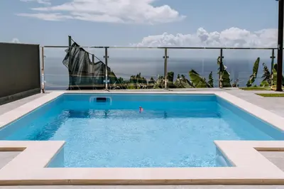 a swimming pool with a view of the ocean at Casa das Voltinhas in Ponta do Sol