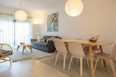 a kitchen with white counters and a large window at Santa Maria Apartment at Porto de Mos beach in Lagos