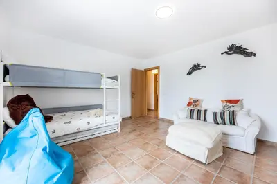 a room with a bunk bed and a couch at Casa dos Sonhadores in Aljezur