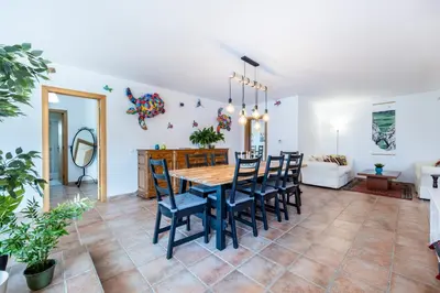 a dining room and living room with a table and chairs at Casa dos Sonhadores in Aljezur