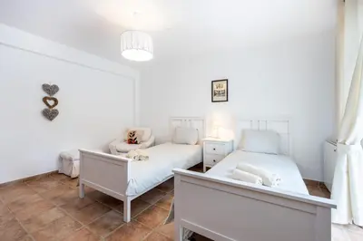 a bedroom with two beds and a couch at Casa dos Sonhadores in Aljezur