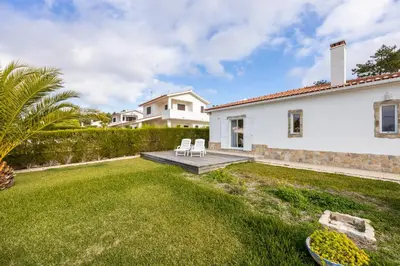 a yard with two chairs and a house at Casa dos Sonhadores in Aljezur