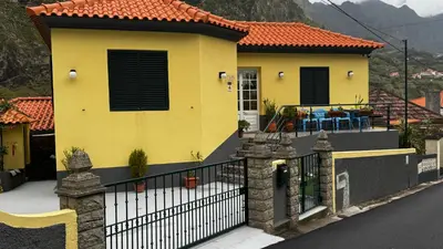 a yellow house with a fence in front of it at Terra Chã Cottage,FEEL Home, in São Vicente