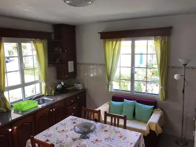 a kitchen with a table and a couch and two windows at Terra Chã Cottage,FEEL Home, in São Vicente