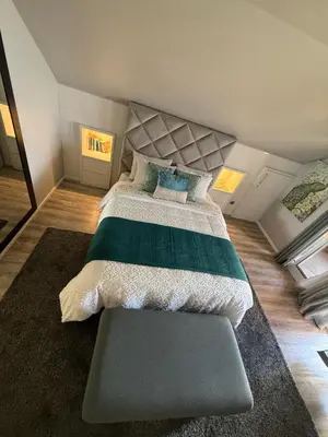 a bedroom with a large bed with a green and white comforter at Studio privado com vista mar e montanha in Ponta do Sol