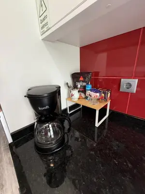 a bathroom with a coffee maker and a table at Studio privado com vista mar e montanha in Ponta do Sol