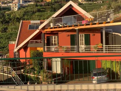 a orange house with a car parked in front of it at Studio privado com vista mar e montanha in Ponta do Sol