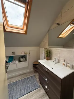 a bathroom with a sink and a skylight at Studio privado com vista mar e montanha in Ponta do Sol