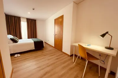 a hotel room with a bed and a desk and a table at Living Funchal X in Funchal
