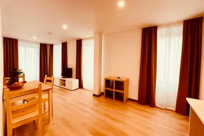 a living room with a table and a television at Living Funchal X in Funchal