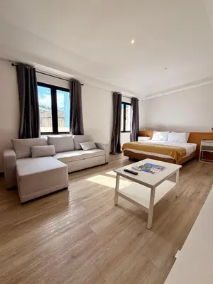 a room with two beds and a couch and a table at Living Funchal X in Funchal