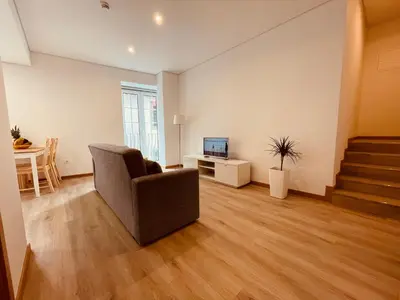 an empty living room with a chair and a television at Living Funchal X in Funchal