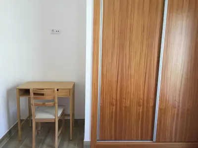 a table and a chair next to a wooden cabinet at Calheta Ocean View Apartments 1 - Air Condition in Estreito da Calheta