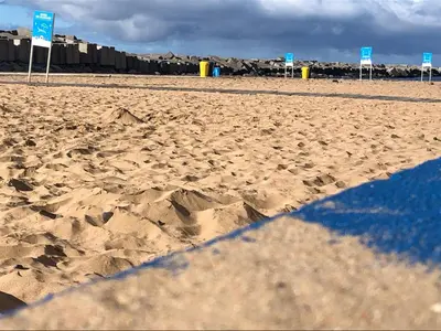 a sandy beach with some blue signs on it at Calheta Ocean View Apartments 1 - Air Condition in Estreito da Calheta