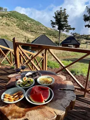 a table with plates of food on a wooden table at Mountain Eco Shelter 1 in Funchal