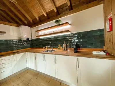 a kitchen with white cabinets and a wooden counter top at Mountain Eco Shelter 2 in Funchal