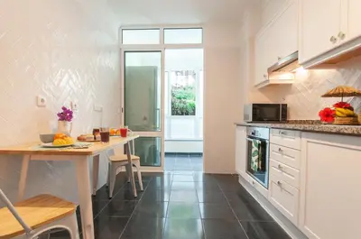 a kitchen with white cabinets and a table with fruits on it at Unique Tropical Style Penthouse with a Dreamy View - by Portugal Collection in Calheta