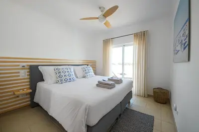 a bedroom with a bed with a ceiling fan at Casa da costa in Carrapateira