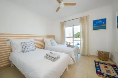 a bedroom with two beds and a window at Casa da costa in Carrapateira