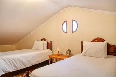 a bedroom with two beds and a window at Villa Mendonça, a Home in Madeira in Canhas