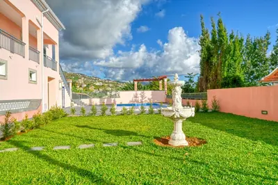 a garden with a fountain in the middle of a yard at Villa Mendonça, a Home in Madeira in Canhas