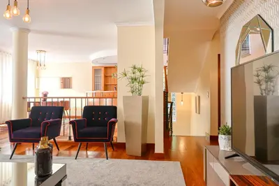 a living room with two chairs and a television at Villa Mendonça, a Home in Madeira in Canhas
