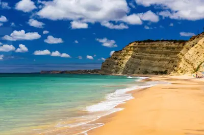 a beach in front of cliffs with the ocean at Spacious Apartment near Porto de Mos Beach, Lagos. in Lagos