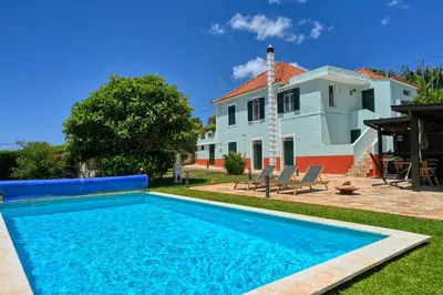 a villa with a swimming pool in front of a house at Villa Santa Madalena, a Home in Madeira in Arco da Calheta