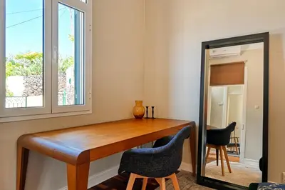 a room with a table and two chairs and a mirror at Villa Santa Madalena, a Home in Madeira in Arco da Calheta
