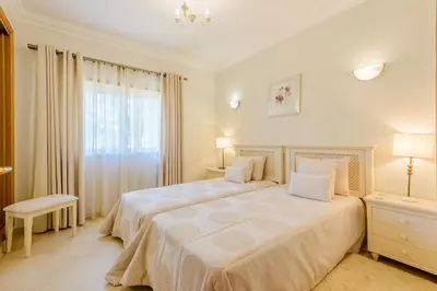 a white bedroom with a large bed and a window at Boavista Golf and Spa Resort - 101 in Lagos