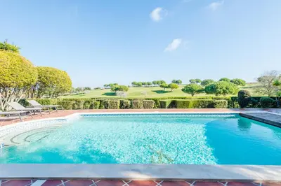 a swimming pool with a golf course in the background at Boavista Golf and Spa Resort - 101 in Lagos