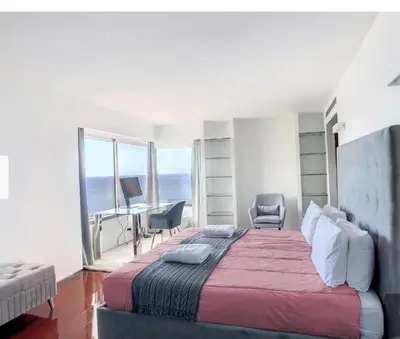 a bedroom with a large bed and a bathroom at Luxurious Penthouse Suites direct on sea in Caniço