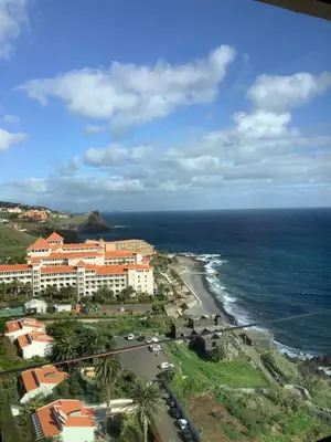a cactus next to the ocean with a resort at Luxurious Penthouse Suites direct on sea in Caniço