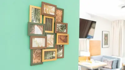 a wall of framed pictures on a blue wall at The Seaview Studio by LovelyStay in Caniço