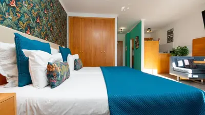 a bedroom with a large bed with blue and white pillows at The Seaview Studio by LovelyStay in Caniço