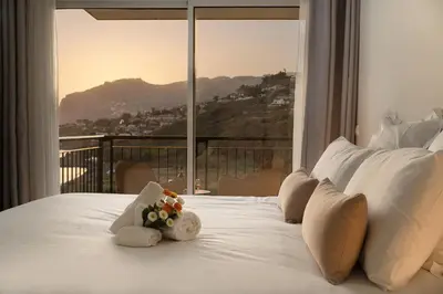 a bedroom with a white bed with a large window at Infinity pool & Amazing Sunset Ocean View in Funchal