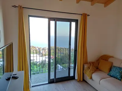 a living room with a sliding glass door at Ponta do Sol Private Apartment Sea View in Ponta do Sol