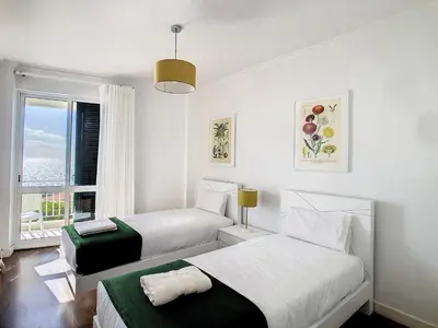 two beds in a white room with a window at Lido Life Apartment by LovelyStay in Funchal