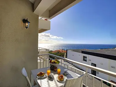 a balcony with a table and a view of the ocean at Lido Life Apartment by LovelyStay in Funchal