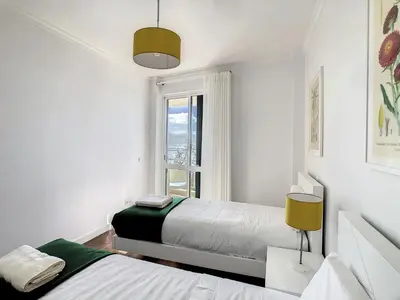 a white bedroom with two beds and a window at Lido Life Apartment by LovelyStay in Funchal