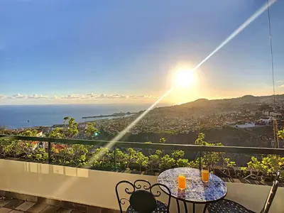 a table and chairs on a balcony with a view of the ocean at Casa Bergmann by LovelyStay in Funchal