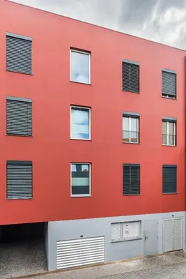a red building with black shuttered windows at Casa da Praça Double room - by Casas na Ilha in Funchal