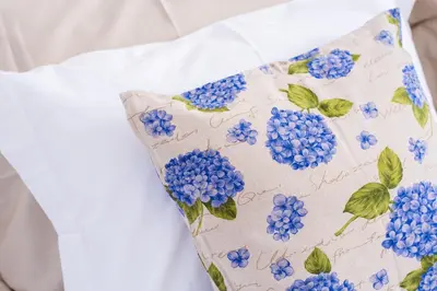 a pillow with blue flowers on a white dress at Casa da Praça Double room - by Casas na Ilha in Funchal