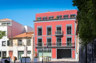 a red building with balconies on a street at Casa da Praça Double room - by Casas na Ilha in Funchal