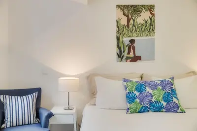 a bedroom with a bed and a blue chair at Casa da Praça Double room - by Casas na Ilha in Funchal